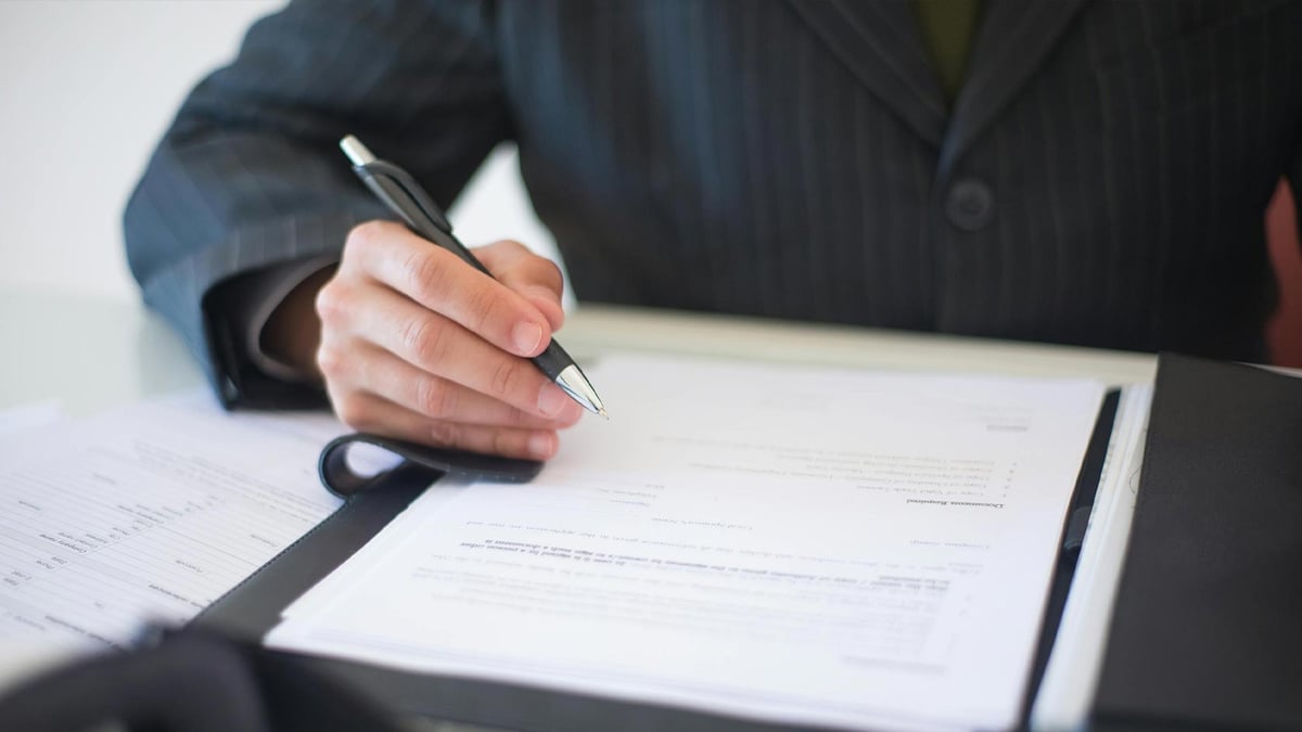 En person signerar ett avtal för svensk licens.